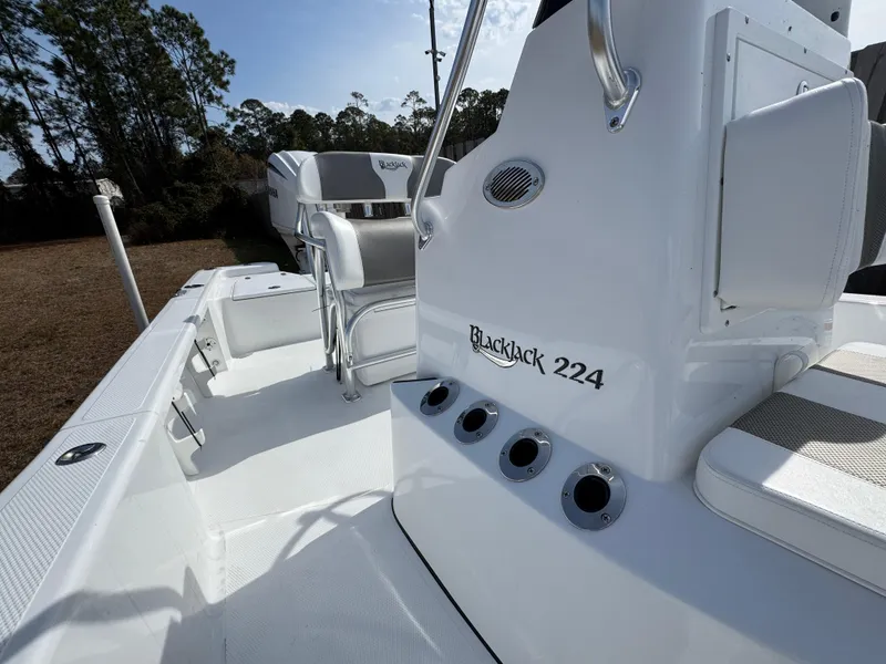 Slide: The Image of 2025 BlackJack 224 boat interior with seating and console, featuring sleek white design. - 9