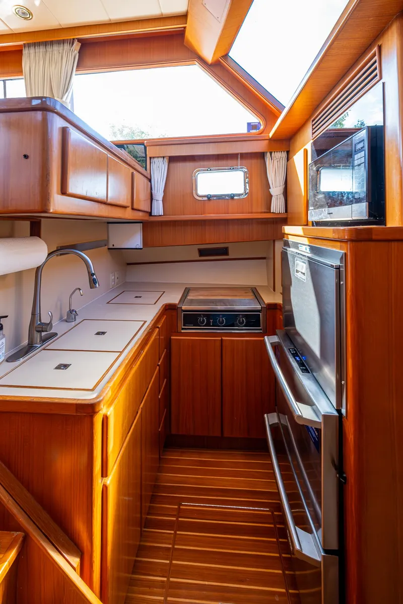 Slide: The Image of Luxurious kitchen interior of a 2002 Symbol 42' yacht with wood finish and modern appliances. - 11