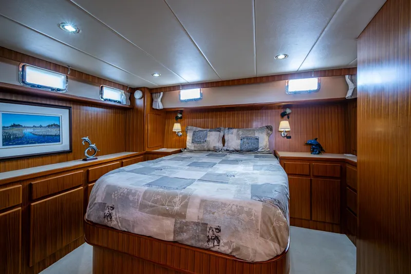 Slide: The Image of Luxurious bedroom interior on a 2002 Symbol 42' yacht with wood paneling and cozy bedding. - 14