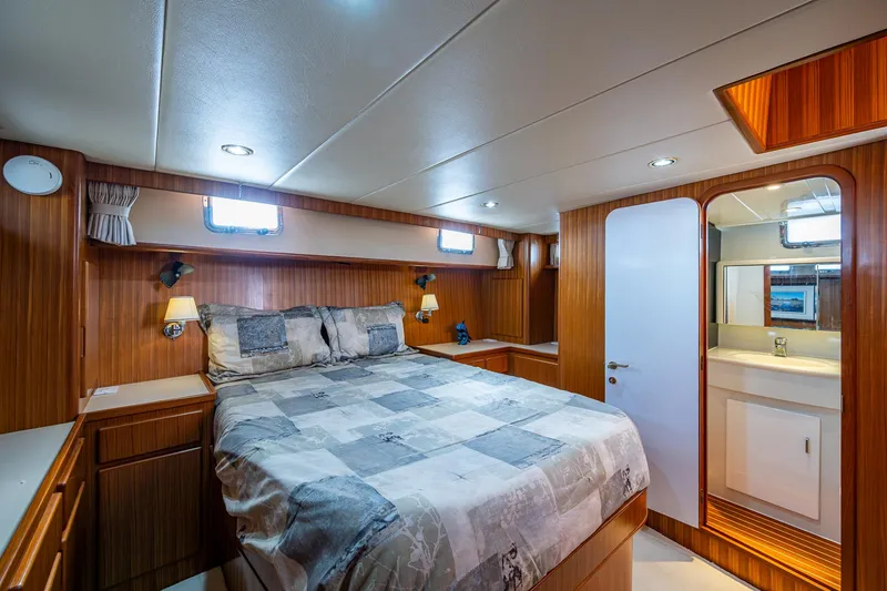 Slide: The Image of Luxurious cabin interior of a 2002 Symbol 42' yacht with cozy bed and wood paneling. - 18
