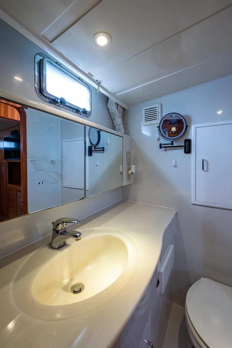 Slide: The Image of Modern bathroom interior on a 2002 Symbol 42' yacht, featuring a sleek sink and mirror. - 21