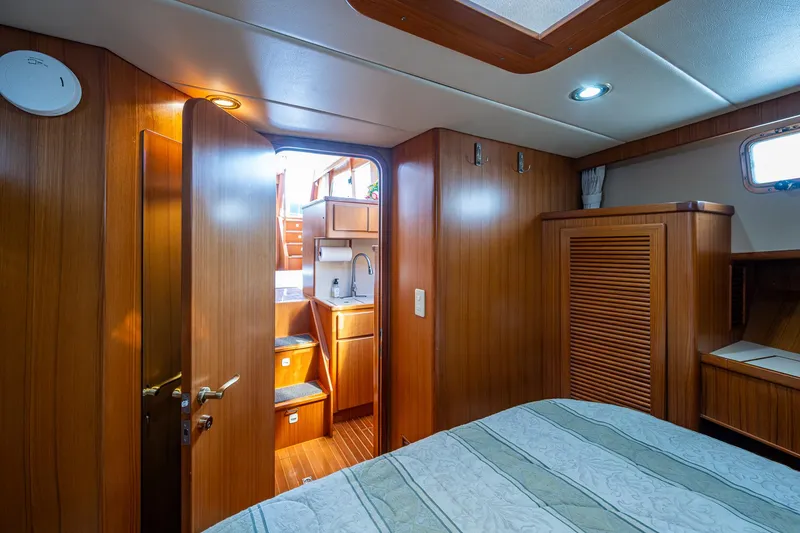 Slide: The Image of Interior of 2002 Symbol 42' yacht, featuring wood paneling and cozy cabin space. - 25