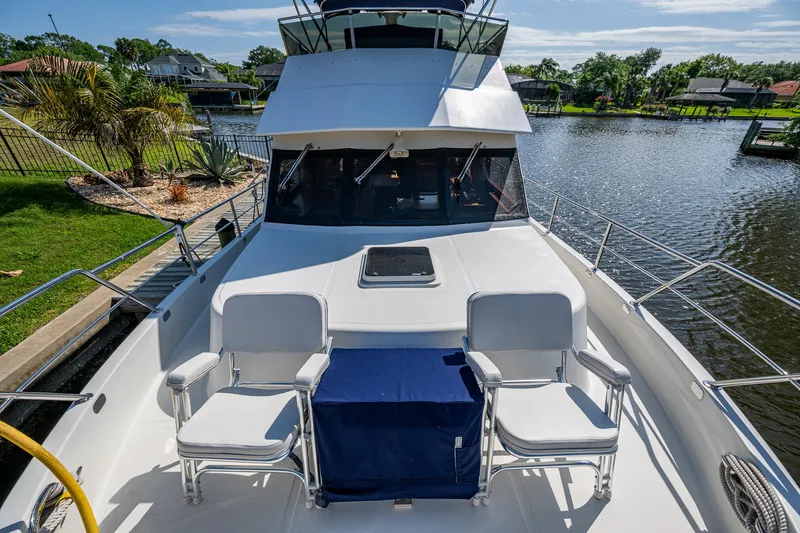 Slide: The Image of Luxury Symbol 42' yacht, 2002 model, docked by a scenic waterfront with seating area. - 35