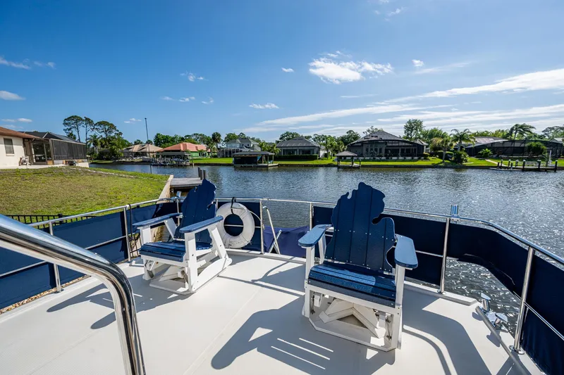 Slide: The Image of Deck view of 2002 Symbol 42' yacht with blue chairs overlooking serene waterfront. - 37