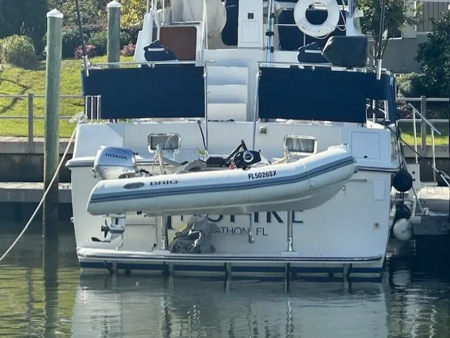 Slide: The Image of A 2002 Symbol 42' yacht docked with an inflatable dinghy attached at the stern. - 44