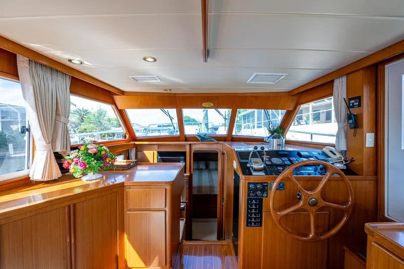 Slide: The Image of Luxurious 2002 Symbol 42' yacht interior with wooden helm and floral arrangement. - 8