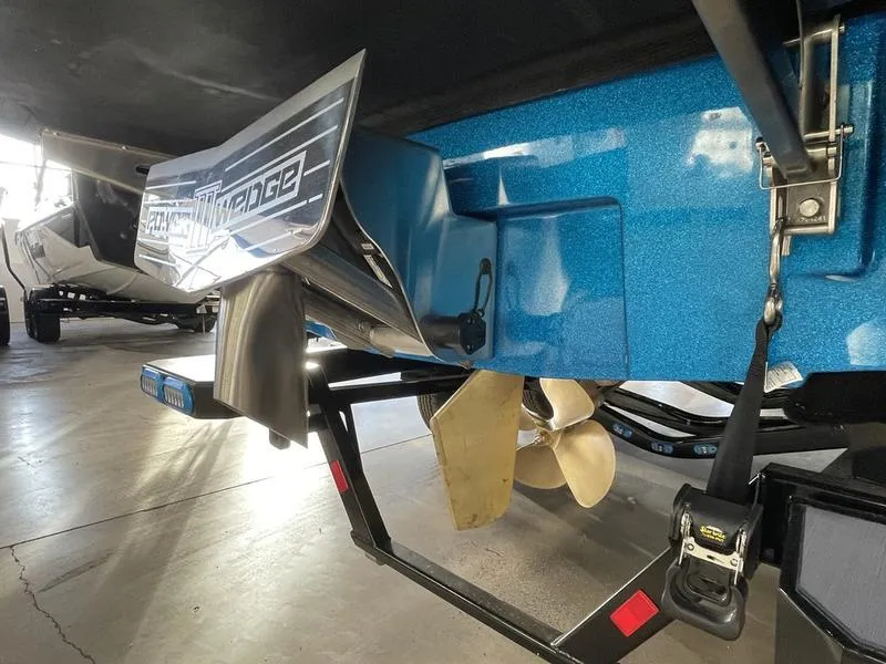 Slide: The Image of 2025 Axis T220 boat with propeller and wakeboard wedge, parked indoors. - 10