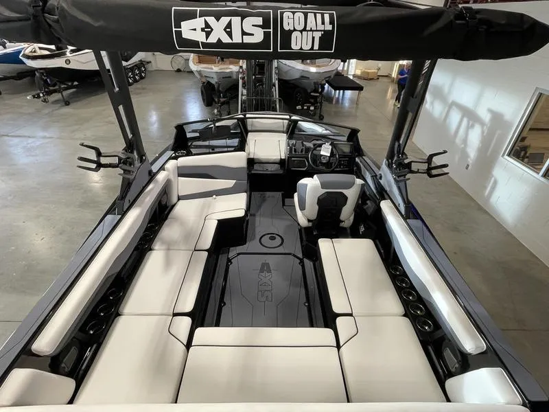 Slide: The Image of 2025 Axis T220 boat interior with spacious seating and modern design in a showroom. - 12