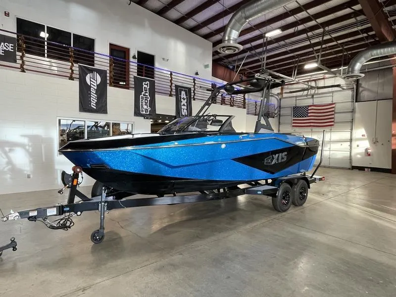 Slide: The Image of 2025 Axis T220 boat in a showroom, blue exterior, on a trailer. - 3