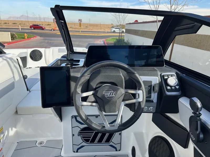 Slide: The Image of 2025 Malibu 23 MXZ boat cockpit with modern steering and digital displays. - 15