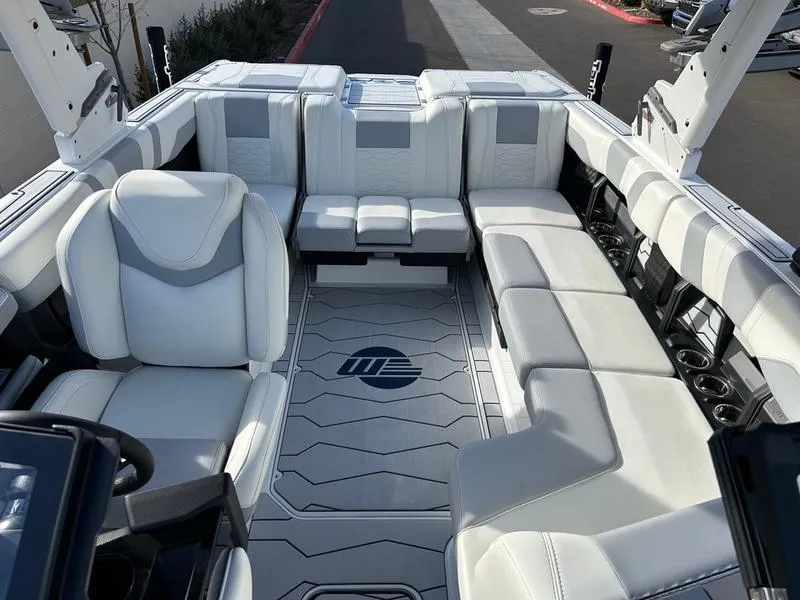 Slide: The Image of 2025 Malibu 23 MXZ boat interior with luxurious white seating and modern design. - 16