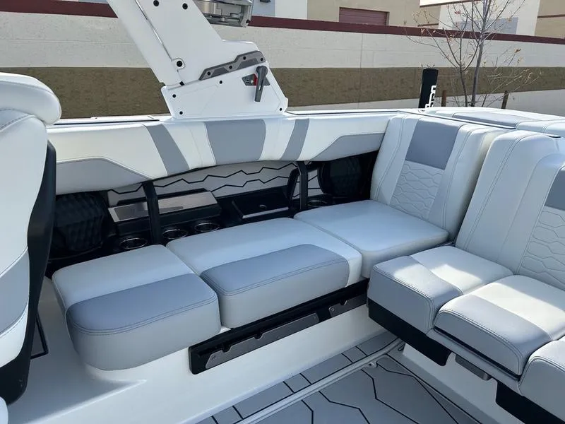 Slide: The Image of 2025 Malibu 23 MXZ boat interior with white and gray seating, modern design. - 17
