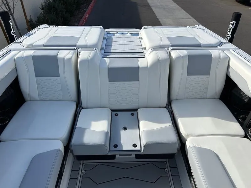 Slide: The Image of 2025 Malibu 23 MXZ boat interior with white cushioned seating. - 18