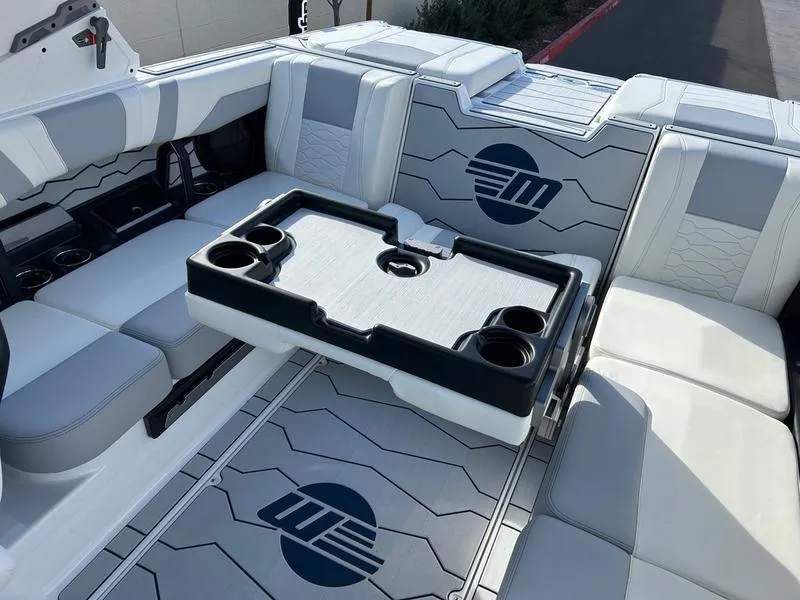 Slide: The Image of 2025 Malibu 23 MXZ boat interior with seating and cup holders. - 21