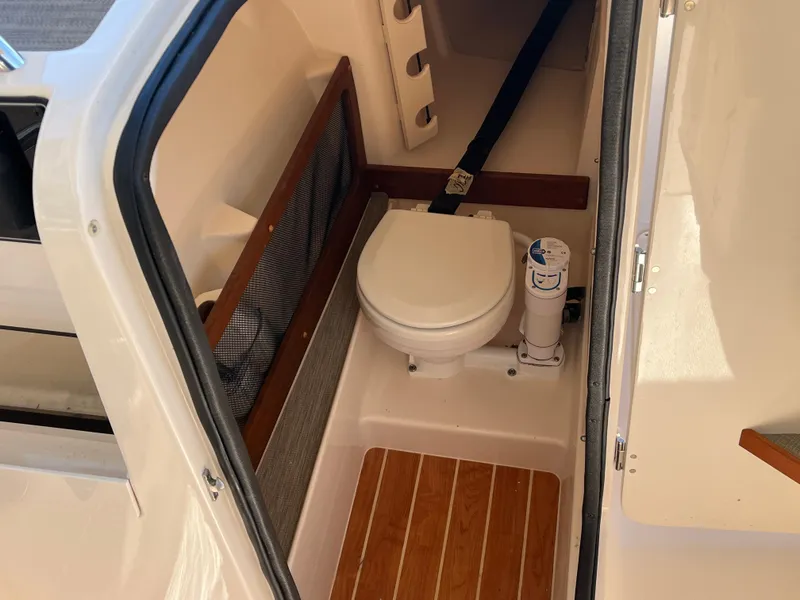 Slide: The Image of 2023 Grady-White Freedom 275 boat interior with compact marine toilet. - 24