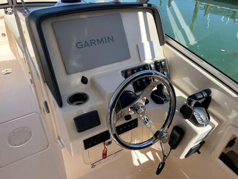 Slide: The Image of 2023 Grady-White Freedom 275 boat dashboard with Garmin navigation system and steering wheel. - 30
