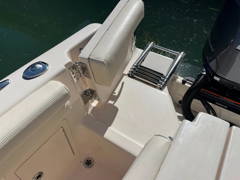 Slide: The Image of 2023 Grady-White Freedom 275 boat interior with seating and ladder near water. - 34
