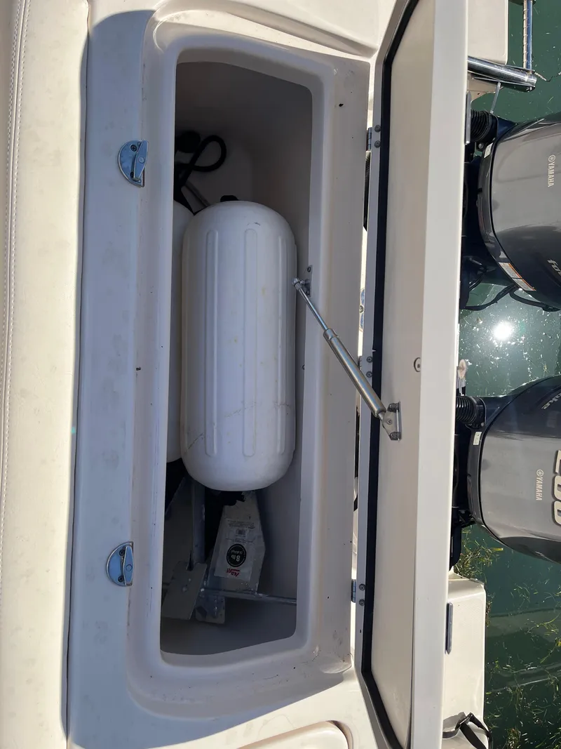 Slide: The Image of Open storage compartment on 2023 Grady-White Freedom 275 boat, showing equipment and dual engines. - 6