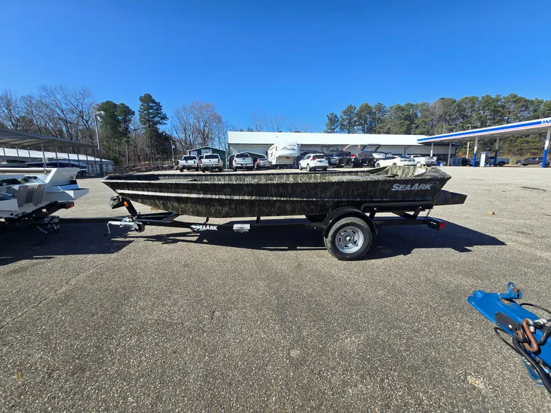 The Image of 2025 SeaArk MV 1652 Jet boat on trailer in parking lot under clear blue sky. - 0