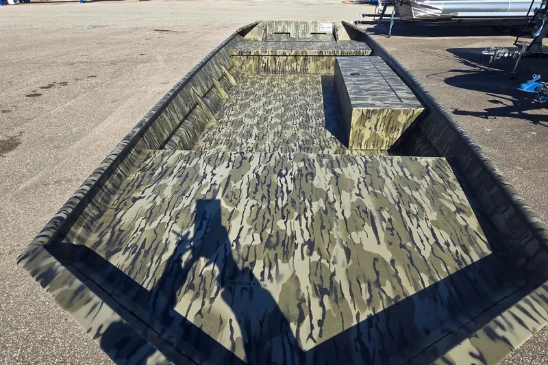 Slide: The Image of 2025 SeaArk MV 1652 Jet boat with camouflage interior, parked on pavement. - 3