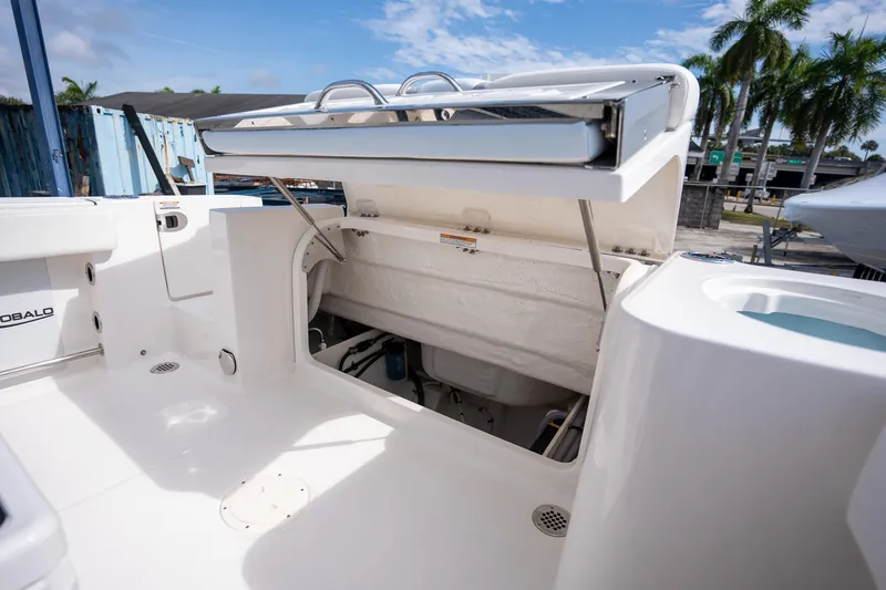 Slide: The Image of 2025 Robalo R230 Center Console boat with open storage compartment, white interior. - 4