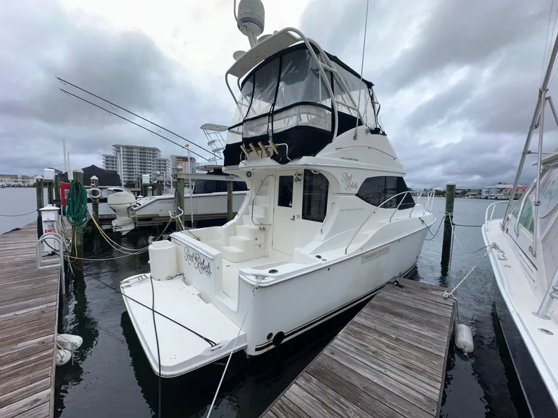 Slide: The Image of 2007 Silverton 330 Sport Bridge docked at marina under cloudy skies. - 1