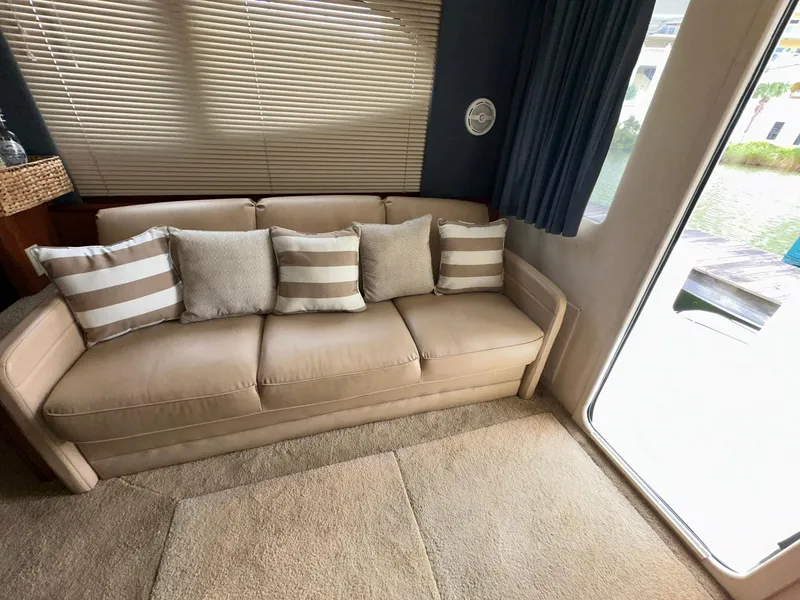 Slide: The Image of Interior of 2007 Silverton 330 Sport Bridge with beige sofa and striped cushions. - 15