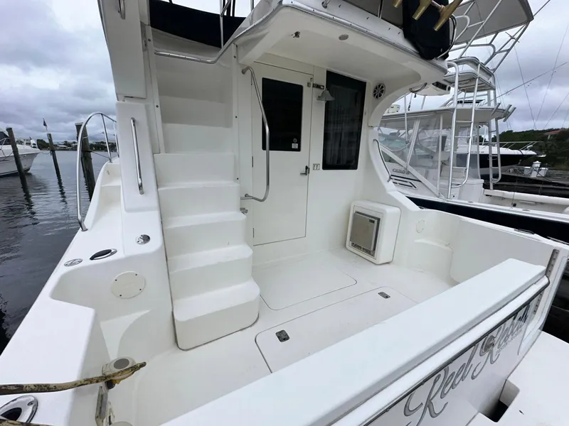 Slide: The Image of 2007 Silverton 330 Sport Bridge boat deck with stairs and marina view. - 2