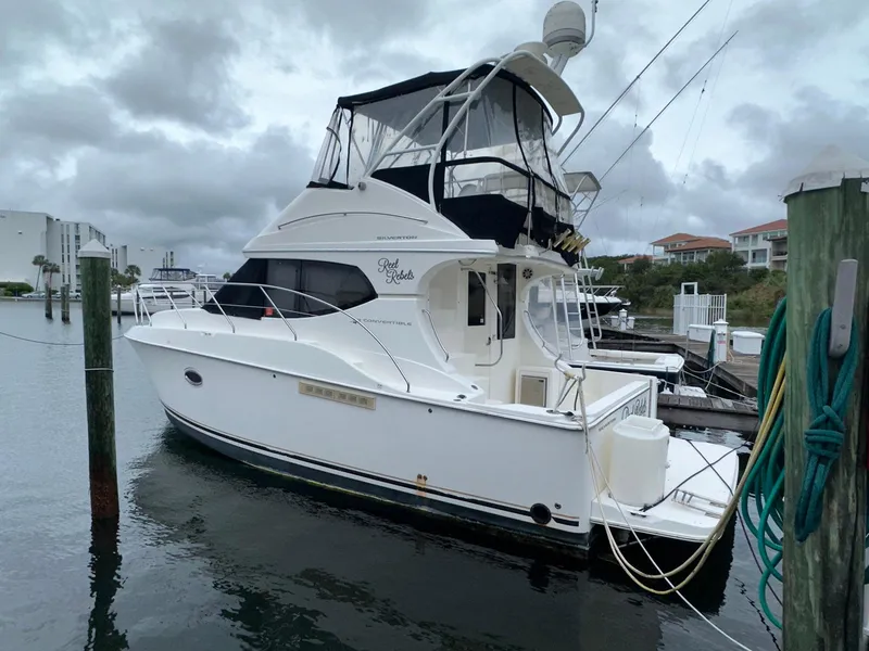 Slide: The Image of 2007 Silverton 330 Sport Bridge yacht docked in a marina under cloudy skies. - 3