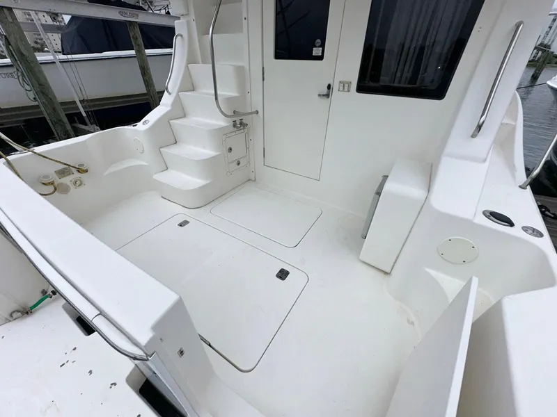 Slide: The Image of 2007 Silverton 330 Sport Bridge boat deck with white seating and stairs. - 7