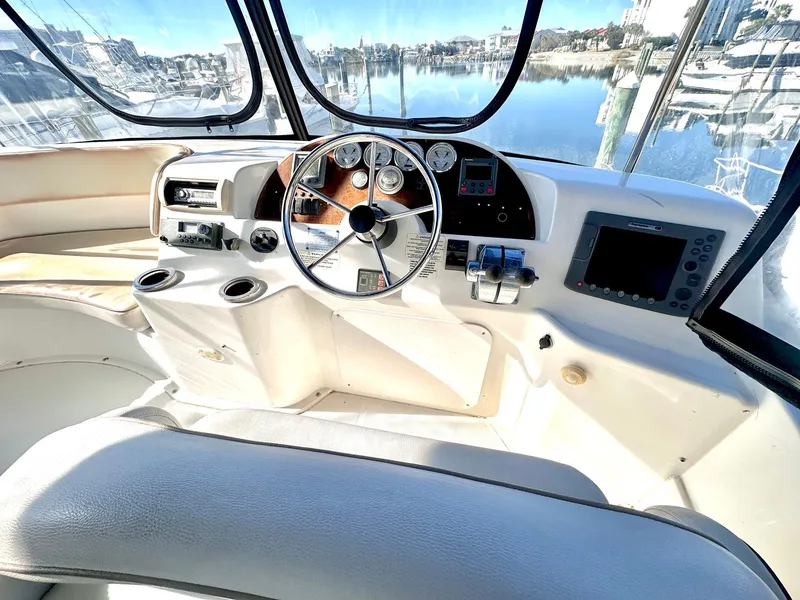 Slide: The Image of 2007 Silverton 330 Sport Bridge helm with modern controls and panoramic marina view. - 8