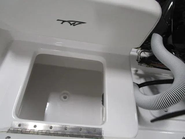 Slide: The Image of 2025 Tidewater 198 CC Adventure boat compartment with open lid and visible hoses. - 16