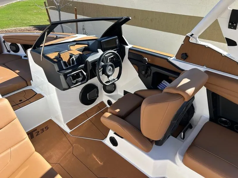 Slide: The Image of 2025 Axis T235 boat interior with tan seats and modern dashboard design. - 11