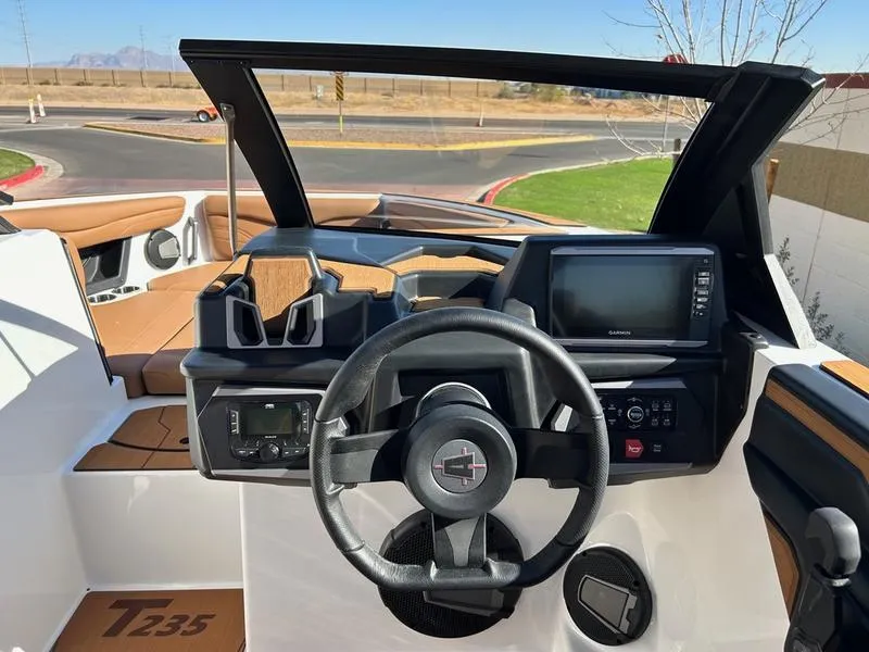 Slide: The Image of 2025 Axis T235 boat dashboard with steering wheel, navigation screen, and control panel. - 13