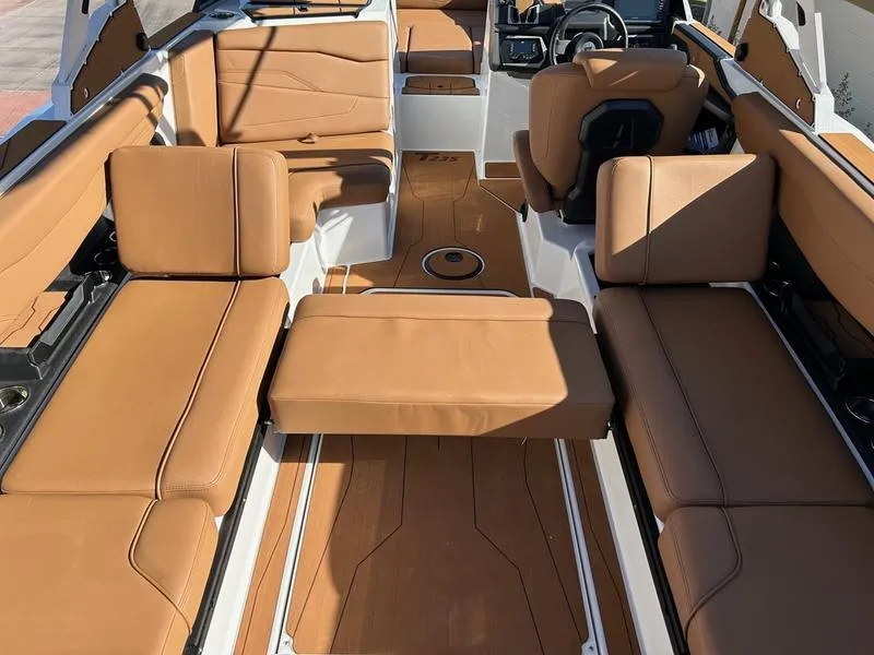 Slide: The Image of 2025 Axis T235 boat interior with tan leather seating and modern dashboard. - 17