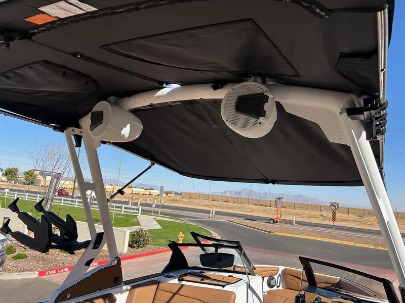 Slide: The Image of 2025 Axis T235 boat with speakers and canopy, parked outdoors. - 18