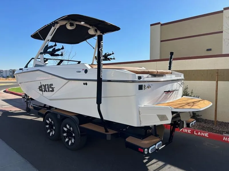 Slide: The Image of 2025 Axis T235 boat on trailer, parked outdoors, showcasing sleek design and modern features. - 4
