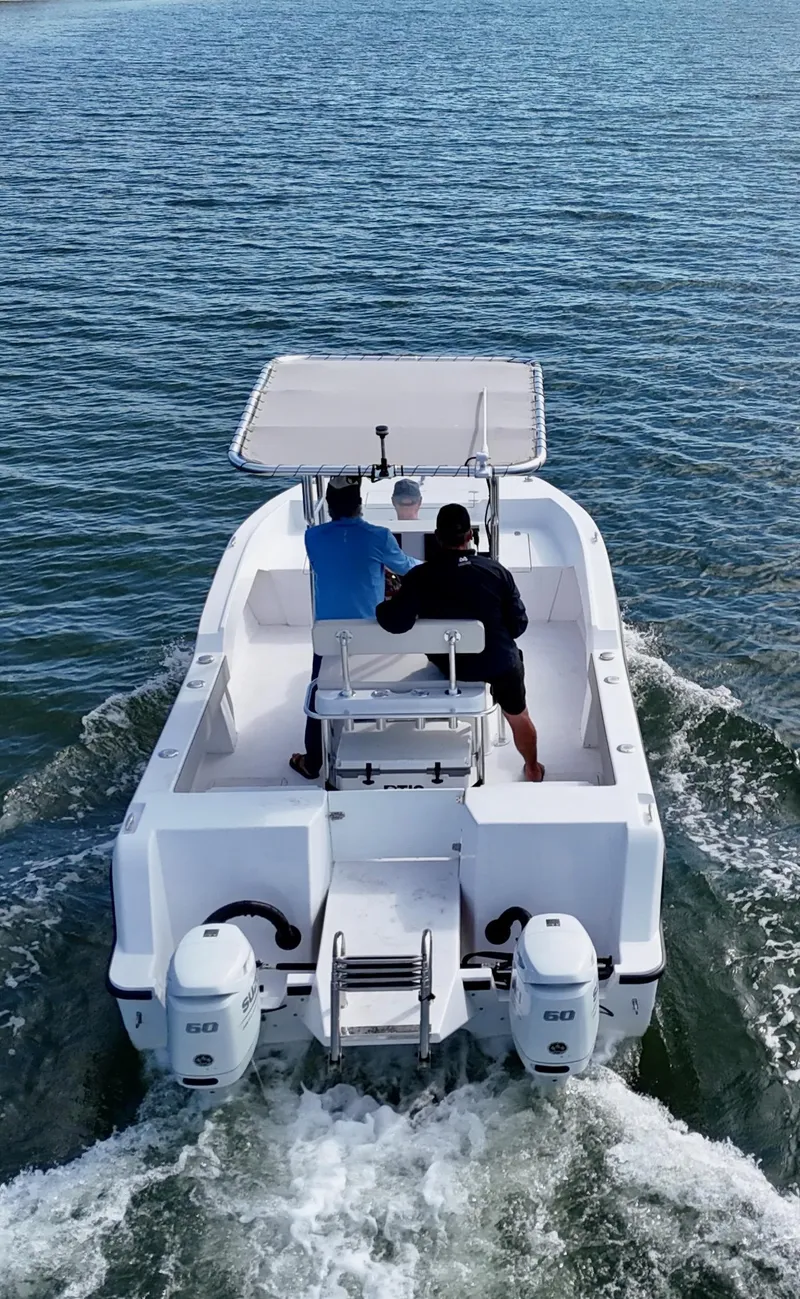 Slide: The Image of 2025 ArrowCat 20 CC boat cruising on open water, featuring dual outboard engines. - 4