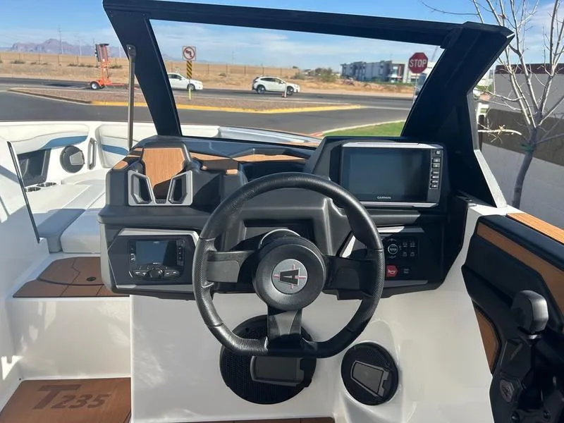Slide: The Image of 2025 Axis T235 boat dashboard with steering wheel and navigation display. - 13