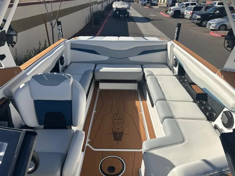 Slide: The Image of 2025 Axis T235 boat interior with white and blue seating, wood flooring, and modern design. - 17