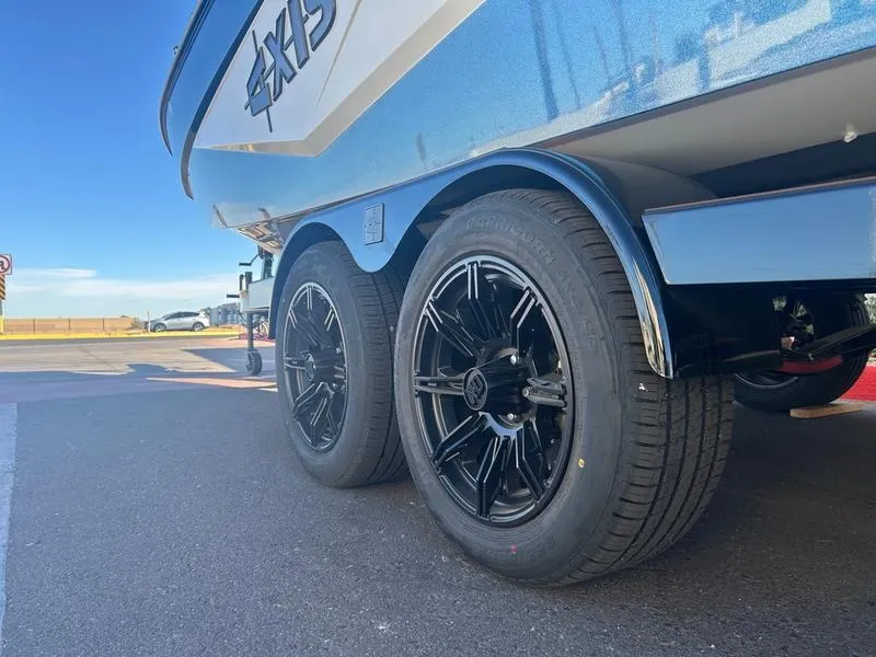 Slide: The Image of 2025 Axis T235 boat trailer with black alloy wheels on a sunny day. - 6