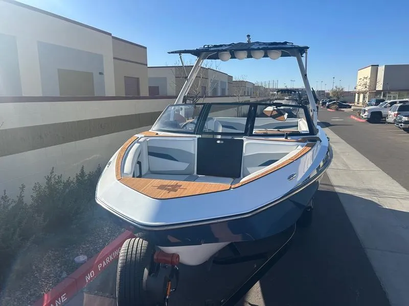 Slide: The Image of 2025 Axis T235 boat on trailer, parked outdoors under clear blue sky. - 8