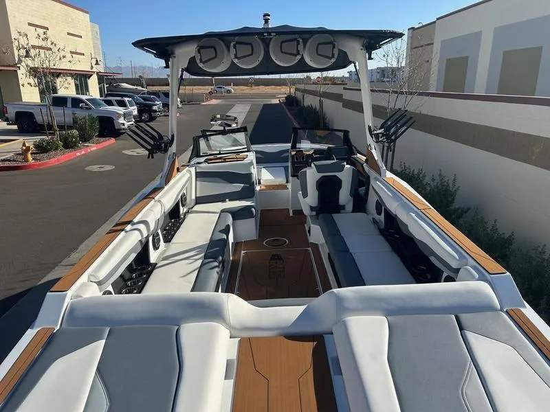 Slide: The Image of 2025 Axis T250 boat with spacious seating and modern design in a parking area. - 11