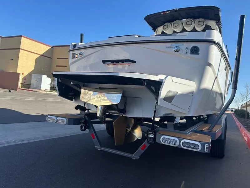 Slide: The Image of 2025 Axis T250 boat on trailer, rear view, parked outdoors. - 5
