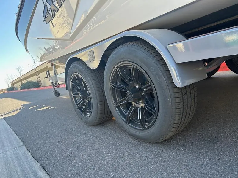 Slide: The Image of 2025 Axis T250 boat trailer with black alloy wheels on a paved road. - 6