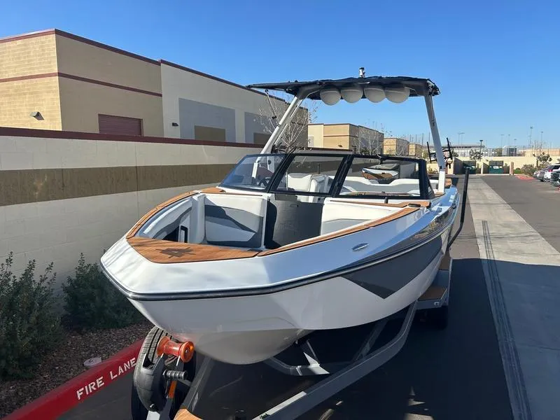Slide: The Image of 2025 Axis T250 boat on trailer, parked outdoors, showcasing sleek design and modern features. - 8