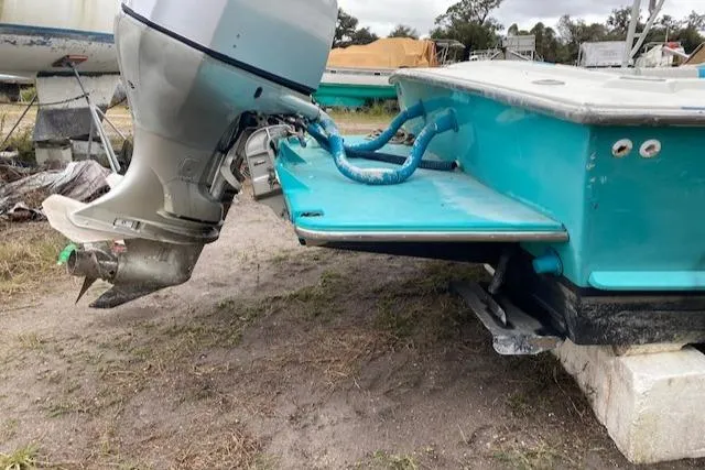 Slide: The Image of 1988 Robertson Sportfish boat with outboard motor, displayed on land. - 4