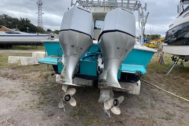 Slide: The Image of 1988 Robertson Sportfish boat with dual outboard motors on land. - 5