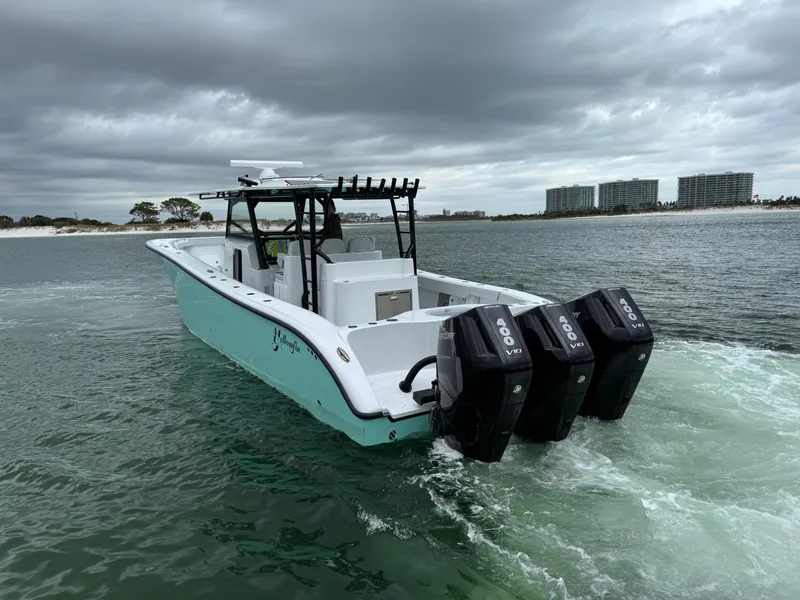 Slide: The Image of 2023 Yellowfin 42 Offshore boat with triple outboard engines on a cloudy day. - 15