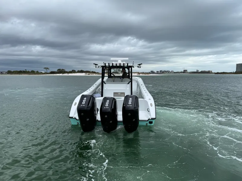 Slide: The Image of 2023 Yellowfin 42 Offshore boat with triple outboard engines on open water. - 16